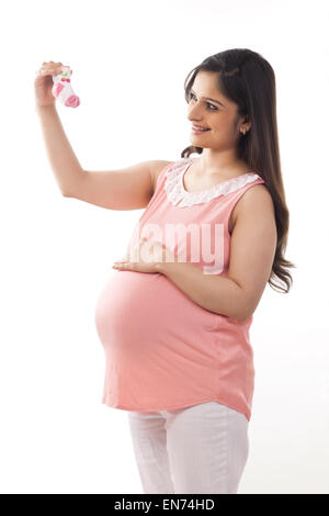 Pregnant woman holding baby shoes Stock Photo
