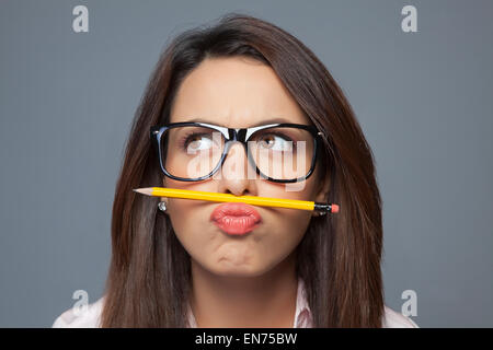 Female executive balancing pencil on lip Stock Photo
