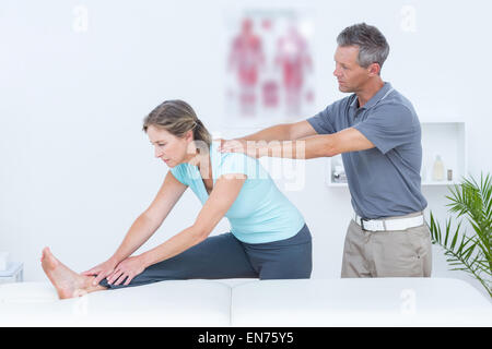 Physiotherapist helping his patient stretching Stock Photo
