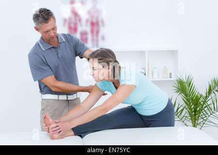 Physiotherapist helping his patient stretching Stock Photo