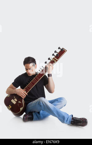 Young man playing the sitar Stock Photo