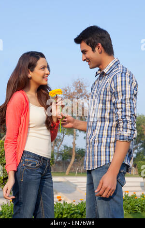 Young man hanging a picture on the wall while young woman looks Stock Photo