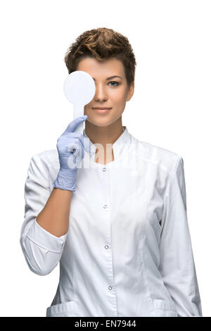 Optometry concept - pretty young woman closes eye Stock Photo