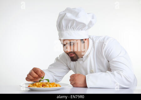 Chef decorating pasta with leaf Stock Photo