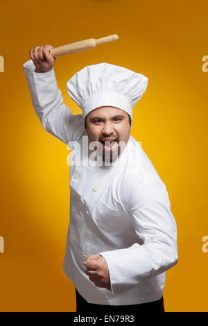 Portrait of angry chef with rolling pin Stock Photo