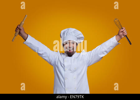 Portrait of chef holding wire whisk and rolling pin Stock Photo