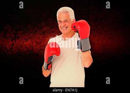 Composite image of senior man in boxing gloves Stock Photo