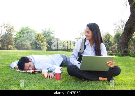 Businessman and businesswoman working in a park Stock Photo