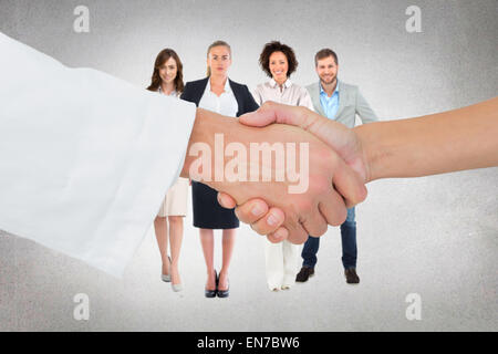 Composite image of extreme closeup of a doctor and patient shaking hands Stock Photo