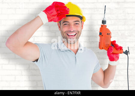 Composite image of smiling manual worker holding drill machine Stock Photo