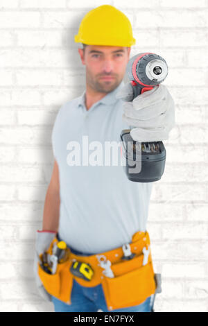 Composite image of portrait of handyman using power drill Stock Photo