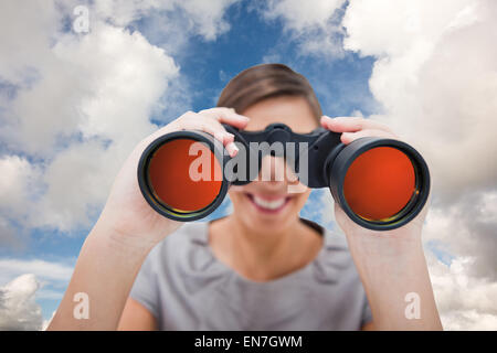 Composite image of woman looking through spyglasses Stock Photo