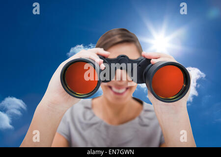 Composite image of woman looking through spyglasses Stock Photo