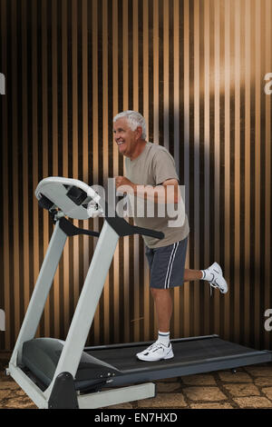 Composite image of full length of a senior man running on a treadmill Stock Photo