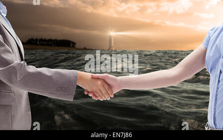Composite image of handshake between two women Stock Photo
