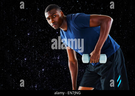 Composite image of portrait of casual young man lifting dumbbell Stock Photo