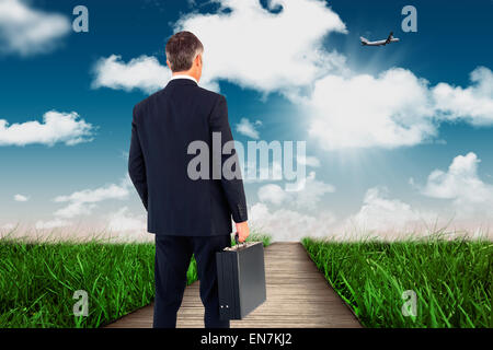 Composite image of businessman in suit looking through binoculars Stock Photo