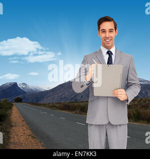 Composite image of happy businessman holding a clipboard Stock Photo