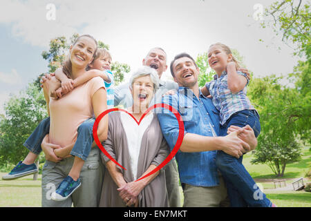 Composite image of portrait of cheerful extended family at park Stock Photo