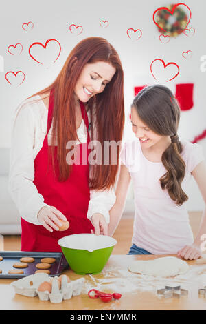 Composite image of festive mother and daughter baking together Stock Photo