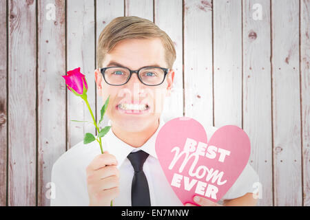 Composite image of geeky hipster holding a red rose and heart card Stock Photo