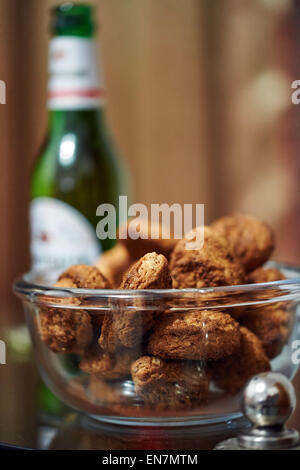 Oatmeal biscuits in a glass bowl with bottle of beer on background Stock Photo