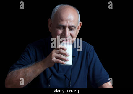 Old man drinking glass of milk Stock Photo