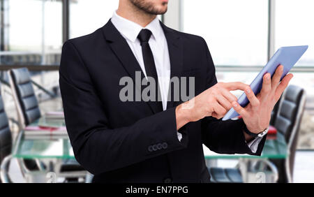 Composite image of mid section of a businessman using digital tablet pc Stock Photo