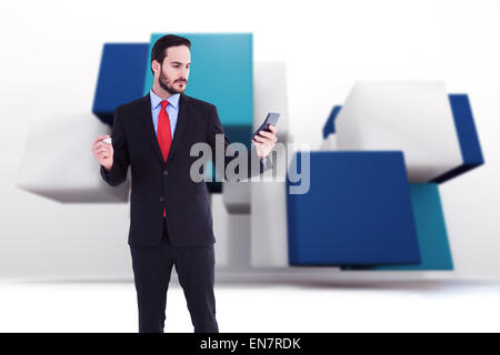 Composite image of handsome businessman texting on phone Stock Photo