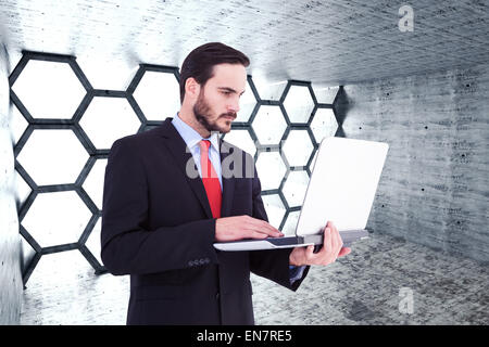 Composite image of focused businessman using his laptop Stock Photo