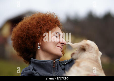 Farmer woman holding a cute baby goat outdoor Stock Photo