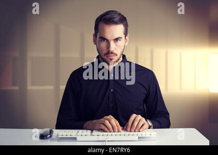 Composite image of serious businessman typing on keyboard Stock Photo