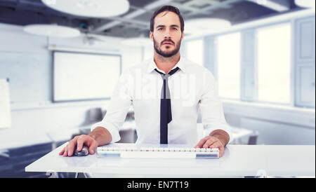 Composite image of focused businessman working on computer Stock Photo