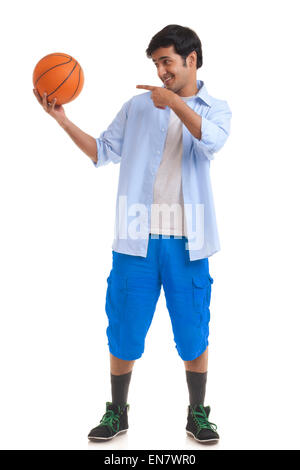 Portrait of young man pointing at basketball