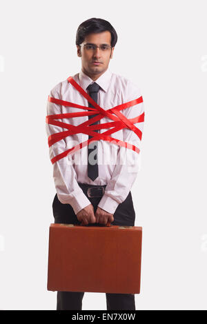 Businessman tied up with red ribbon Stock Photo