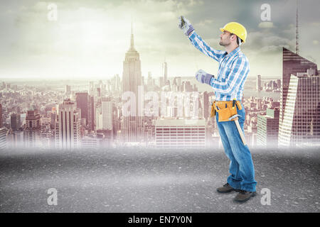Composite image of construction worker using measure tape Stock Photo