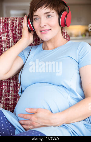 Pretty Pregnant Woman Putting Headphones On Her Belly Stock Photo, Picture  and Royalty Free Image. Image 59147162.