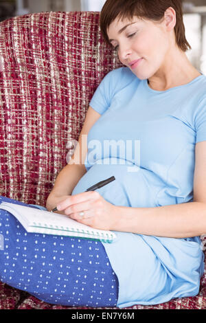 Pregnant woman listing baby names Stock Photo