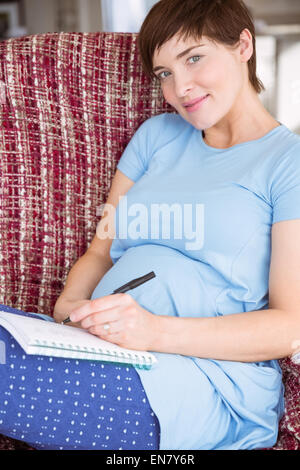 Pregnant woman listing baby names Stock Photo