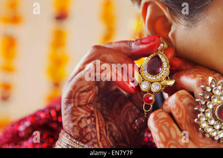 Close-up of a Brides hands putting on an earring Stock Photo