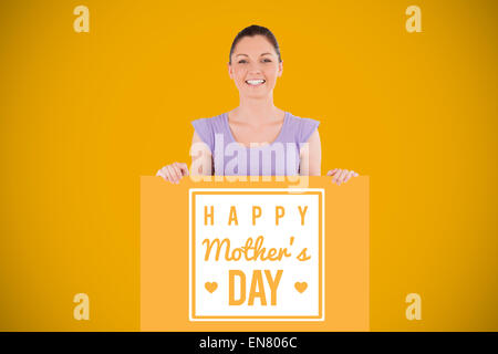 Composite image of portrait of a charming woman posing behind a billboard while standing Stock Photo