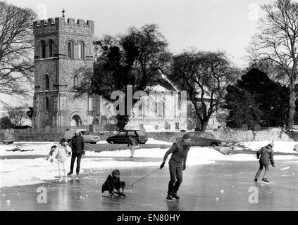 Ice skaters on a frozen Falmer village Pond near Brighton in March 1986 during cold weather Stock Photo