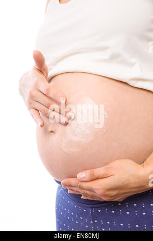 Pregnant woman with cream on bump