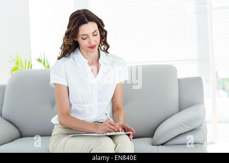 Smiling therapist taking notes Stock Photo