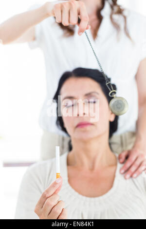 Woman being hypnotized to quit smoking Stock Photo