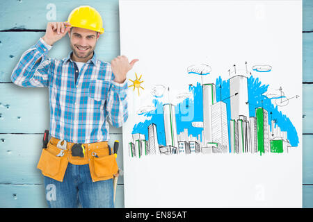 Composite image of happy repairman pointing towards blank billboard Stock Photo
