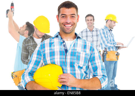 Composite image of smiling handyman holding hardhat and hammer Stock Photo