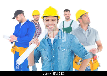 Composite image of confident architect holding rolled blueprint Stock Photo