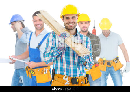 Composite image of construction worker carrying wooden planks Stock Photo