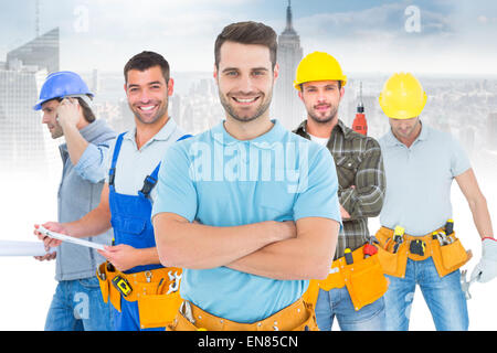 Composite image of happy carpenter standing arms crossed Stock Photo